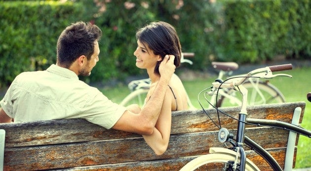 Couple in love fondling herself on a bench with bikes on vacation